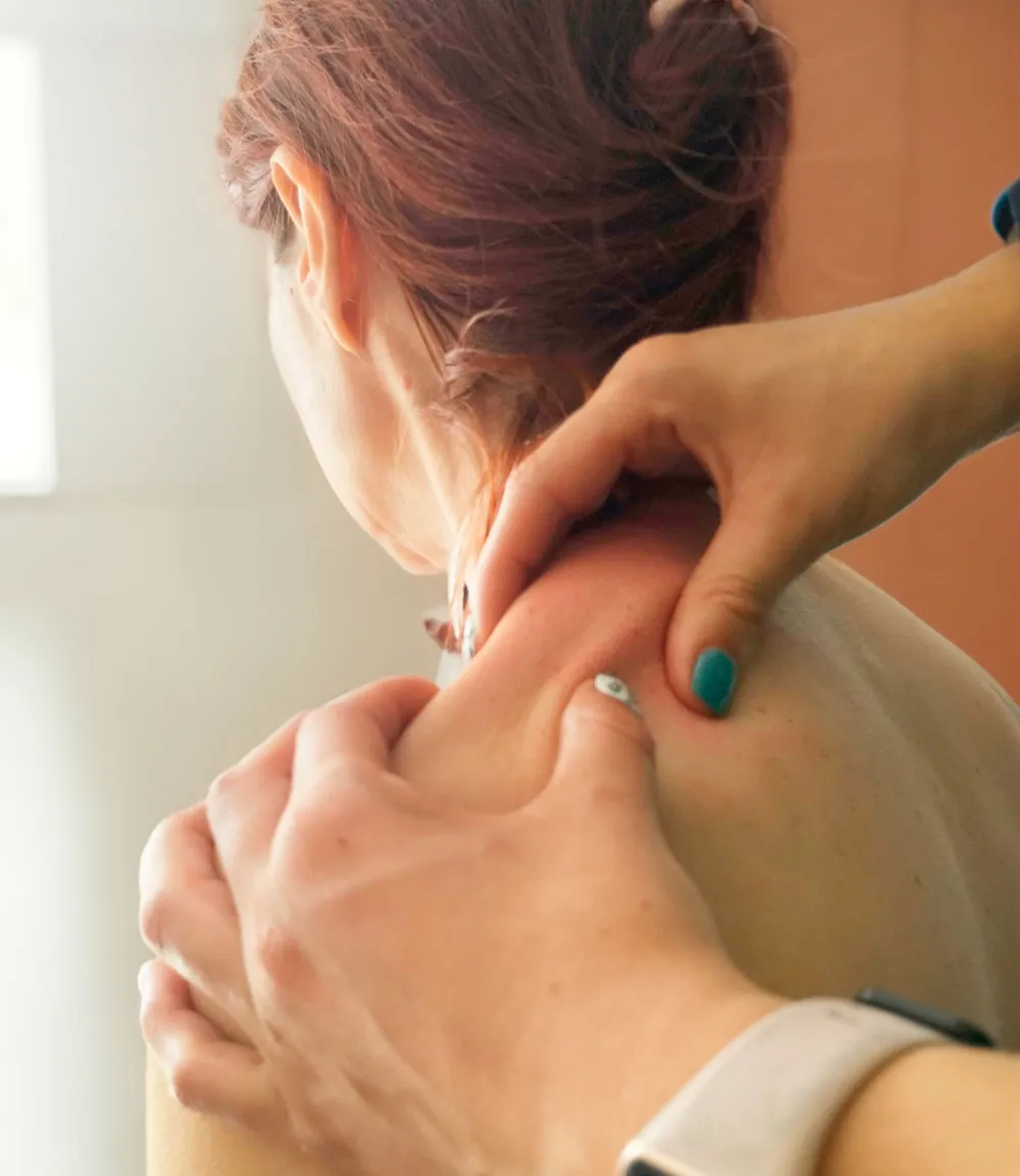 Masaje terapéutico en el cuello y los hombros de una paciente