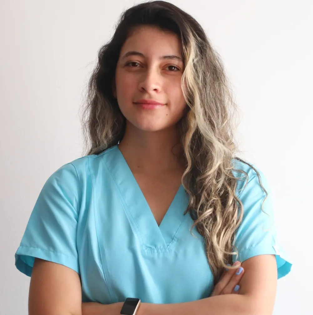 Valentina García, fisioterapeuta, sonriendo con uniforme azul